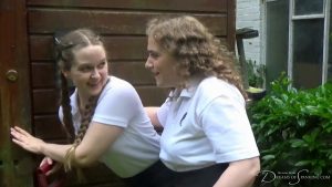 The two girls evesdrop outside the shed