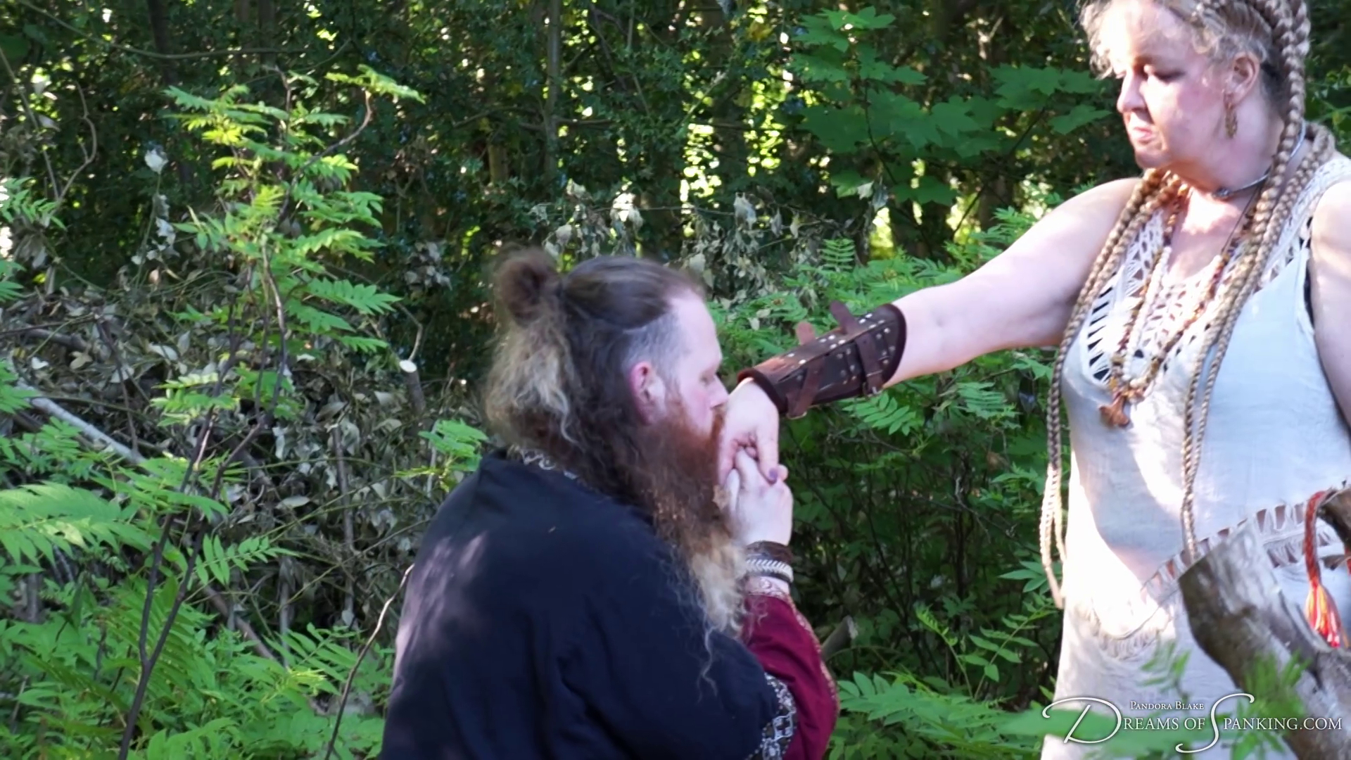 Jamie kneels and kisses his queen's hand after his punishment