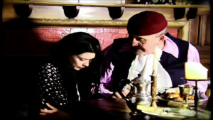 The servant talks to her master at the dinner table.