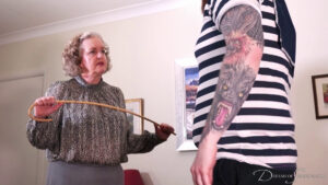 Matilda's aunt holds the cane in both hands as she scolds Jamie