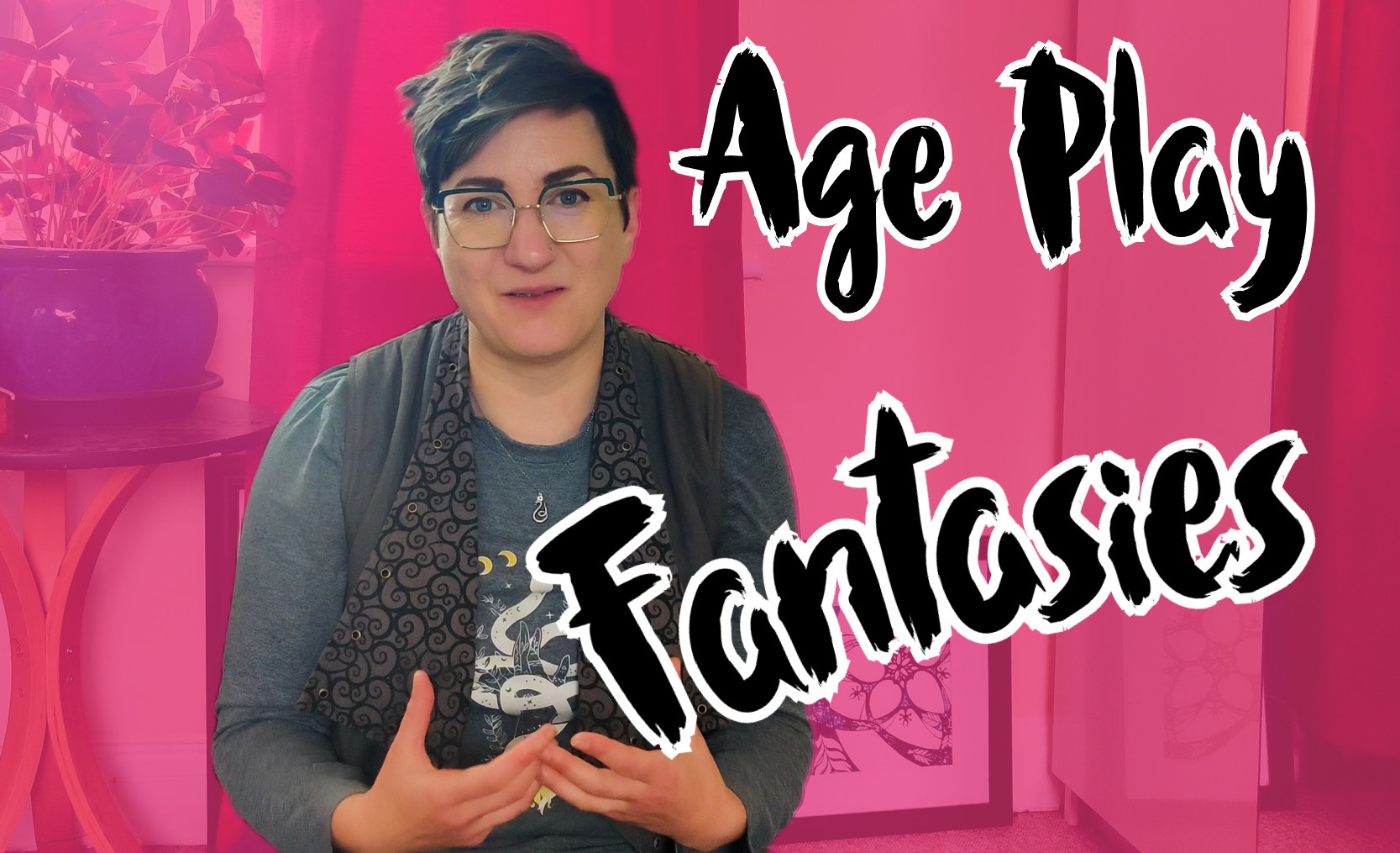 Pandora Blake is sitting and gesturing towards the camera. The background is pink, and the words Age Play Fantasies are overlaid