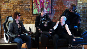 The three gang members and their boss sit together and laugh about their recently completed job