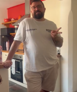 Chris Underwill on set smiling and throwing peace sign for the camera