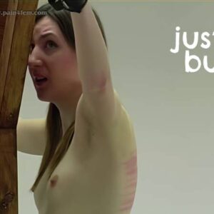 Pandora stands cuffed to a cross, her back exposed as she receives her machine whipping