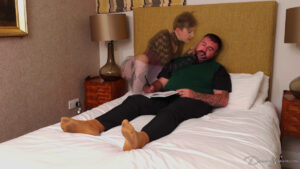 Blake materialises in bed with the priest wearing a corset and fishnet